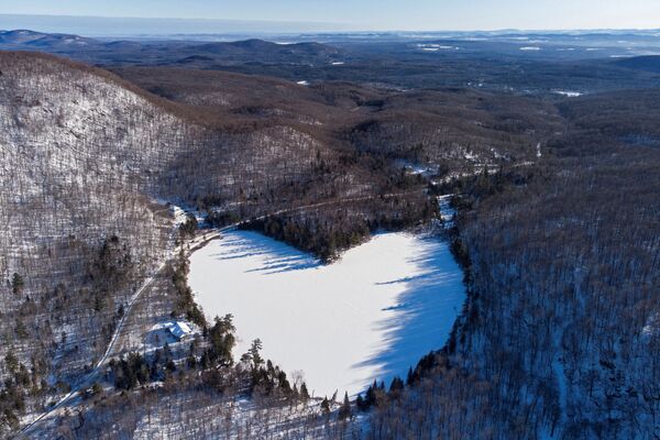 Замерзший и покрытый снегом пруд Бейкер в форме сердца в Ист-Болтоне, близ Квебека в Канаде.  - Sputnik Казахстан