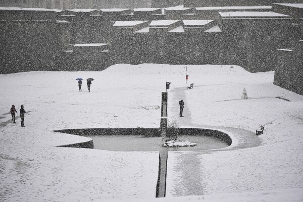 Люди гуляют по площади с прудом, покрытым снегом в испанском городе Памплона. - Sputnik Казахстан