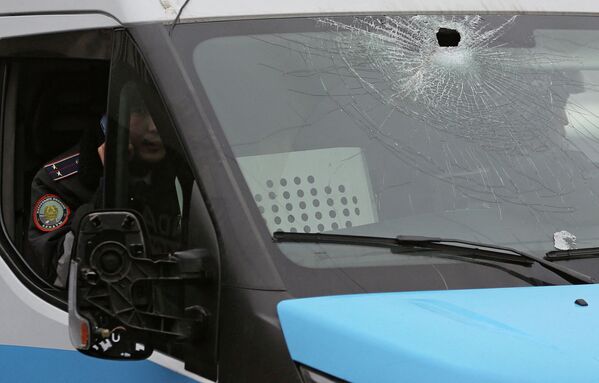 Полицейские сидят в машине с пробитым ветровым стеклом в Алматы. - Sputnik Казахстан