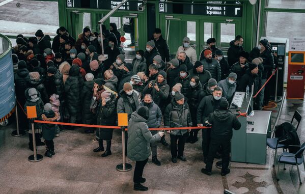Люди пытаются пройти за ограждение в аэропорту Нур-Султана, где задерживают рейсы. - Sputnik Казахстан