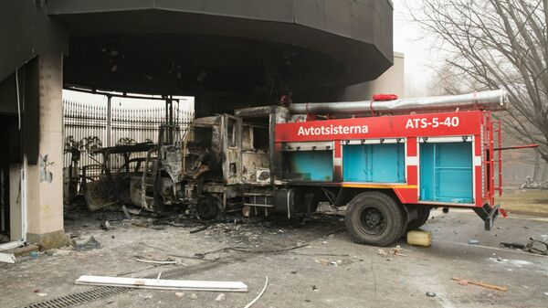 Сгоревшая пожарная машина изображена перед воротами административного здания в центре Алматы 6 января 2022 года - Sputnik Казахстан
