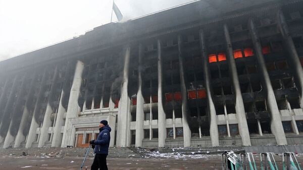 Мужчина стоит перед зданием мэрии, которое было подожжено во время акций протеста в Алматы - Sputnik Қазақстан