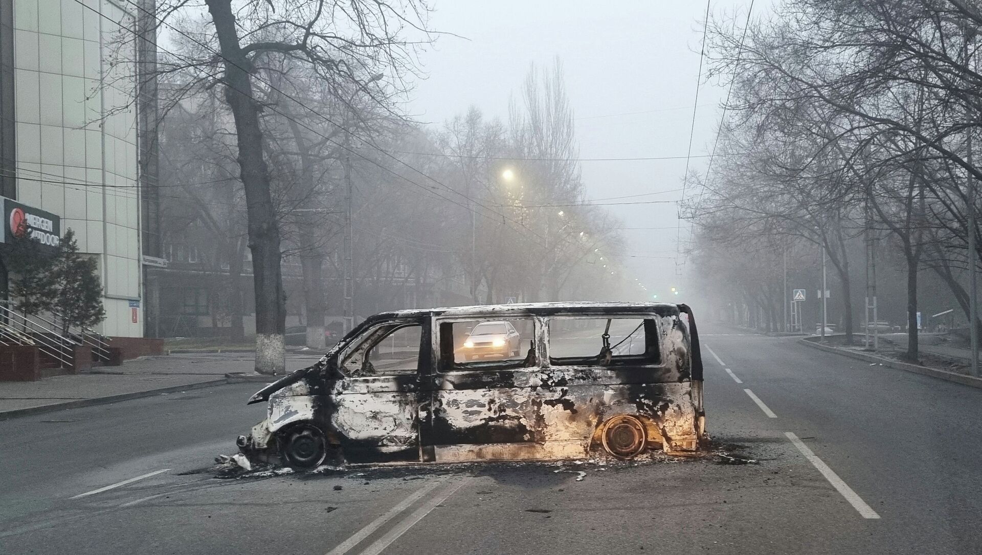 Сгоревший во время протестов автомобиль на дороге в Алматы - Sputnik Казахстан, 1920, 18.01.2022