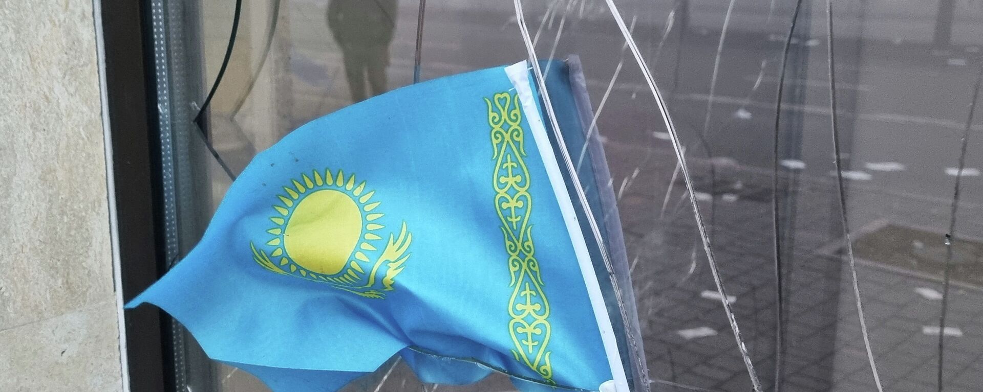 Государственный флаг Казахстана на разбитом окне отделения Kaspi Bank в Алматы - Sputnik Қазақстан, 1920, 20.01.2022