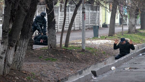 Вооруженный офицер ОМОНа задерживает двух протестующих во время антитеррористической операции безопасности на улице после столкновений в Алматы, Казахстан, в субботу, 8 января 2022 - Sputnik Казахстан