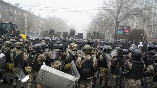ОМОН перекрывает улицу, чтобы помешать демонстрантам во время акции протеста в Алматы, Казахстан, среда, 5 января 2022 г. - Sputnik Казахстан