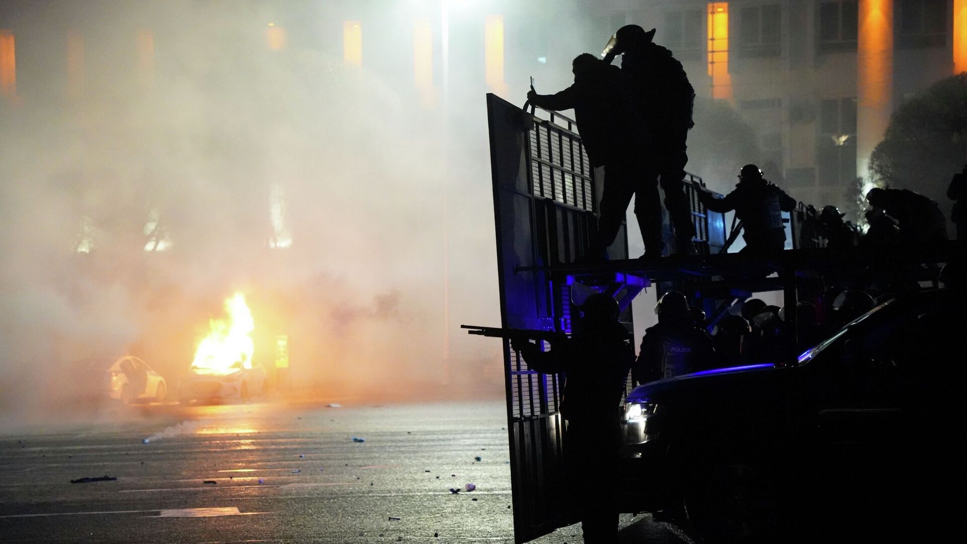 Полицейская машина горит, когда ОМОН готовится остановить демонстрантов в центре Алматы, Казахстан, среда, 5 января 2022 г.  - Sputnik Казахстан, 1920, 18.07.2022
