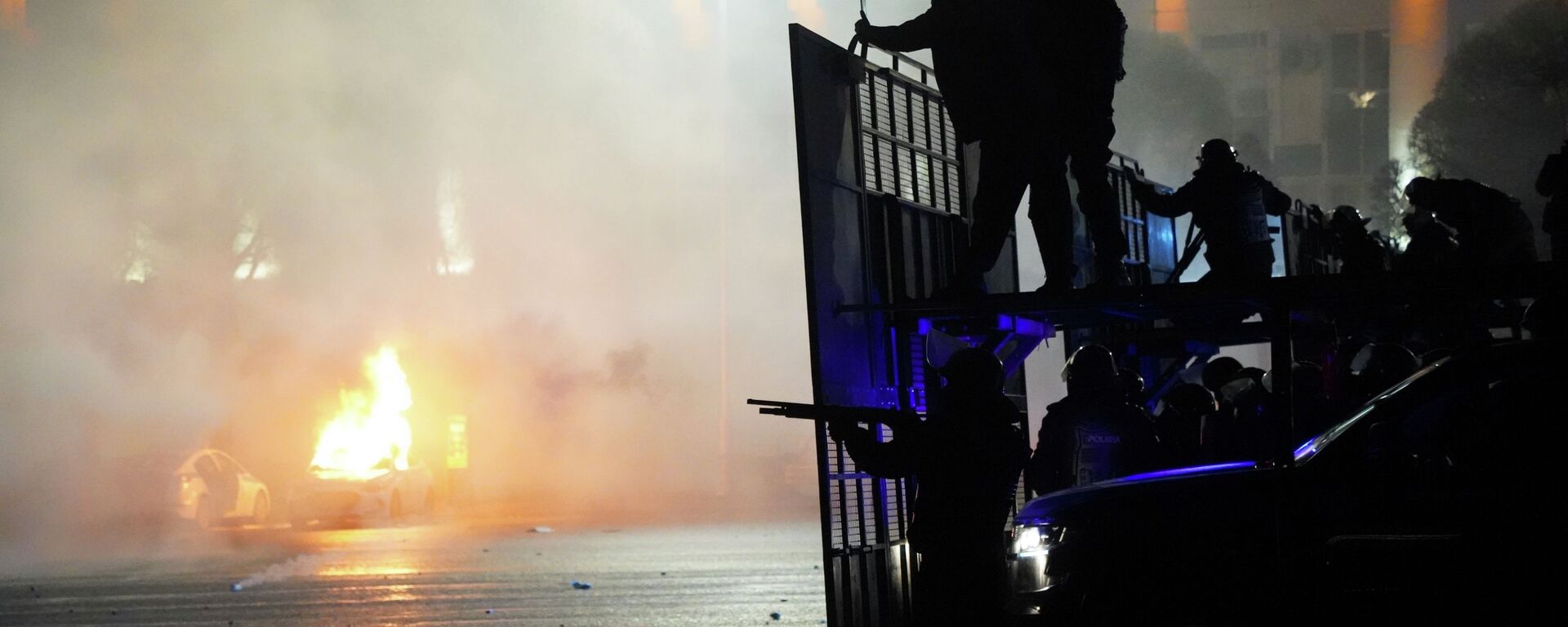 Полицейская машина горит, когда ОМОН готовится остановить демонстрантов в центре Алматы, Казахстан, среда, 5 января 2022 г.  - Sputnik Казахстан, 1920, 05.01.2023