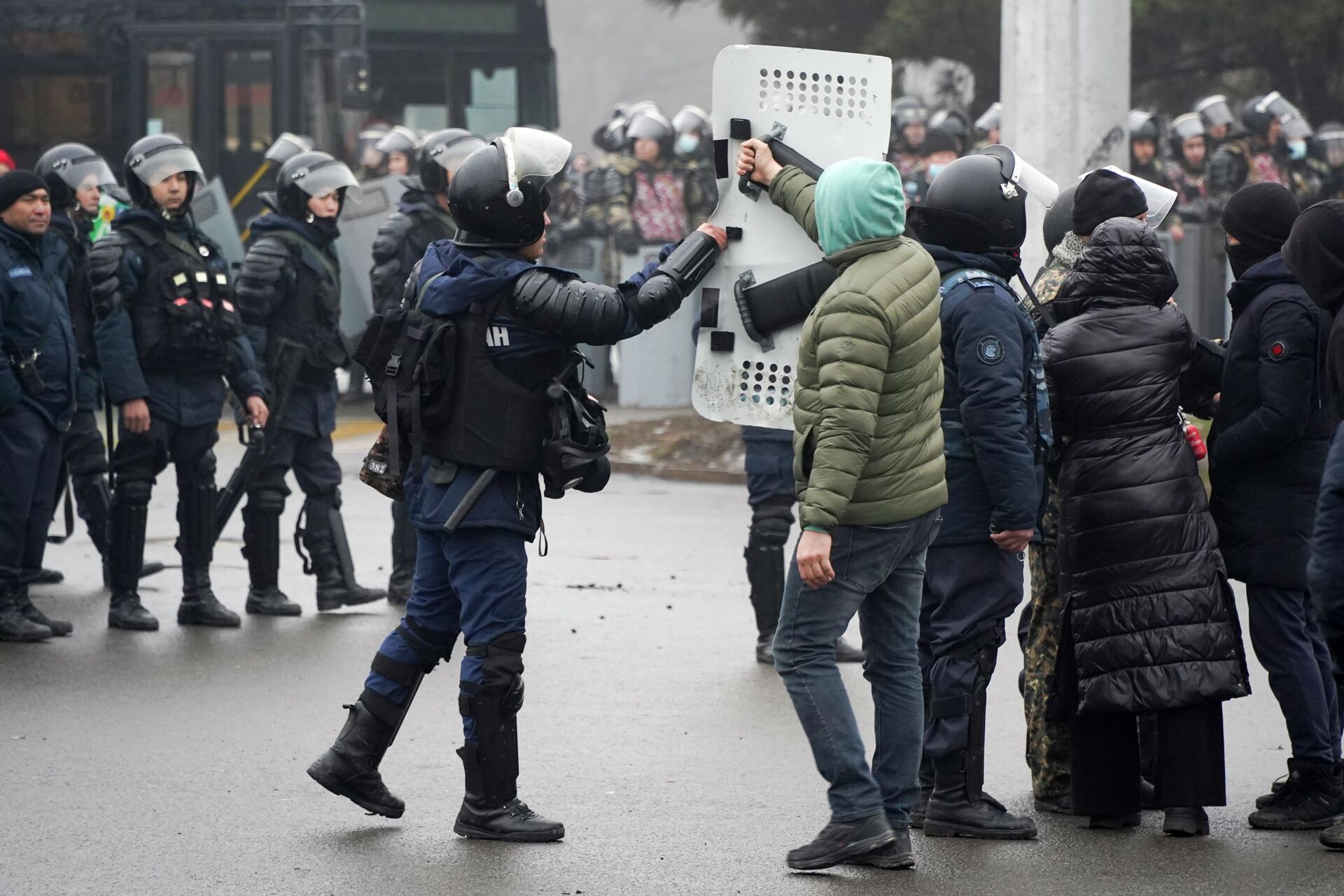 Демонстрант возвращает щит сотруднику ОМОНа во время акции протеста в Алматы, Казахстан, в среду, 5 января 2022 г.  - Sputnik Казахстан, 1920, 02.01.2023