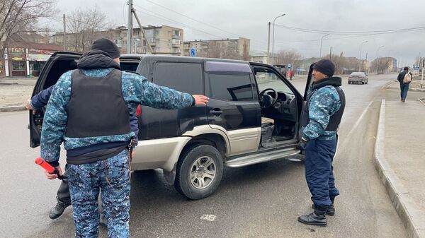 Сотрудники блокпоста осматривают автомобиль в Талдыкоргане  - Sputnik Қазақстан