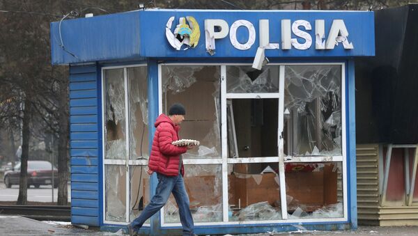 Мужчина проходит мимо полицейского участка, разрушенного во время беспорядков в Алматы - Sputnik Казахстан