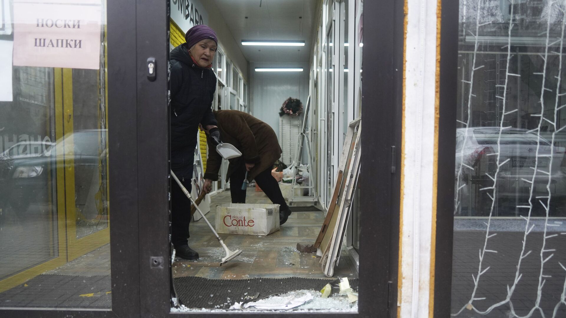Продавцы убирают магазин, который был взломан и разграблен во время столкновений в Алматы - Sputnik Казахстан, 1920, 20.01.2022