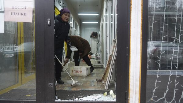 Продавцы убирают магазин, который был взломан и разграблен во время столкновений в Алматы - Sputnik Казахстан