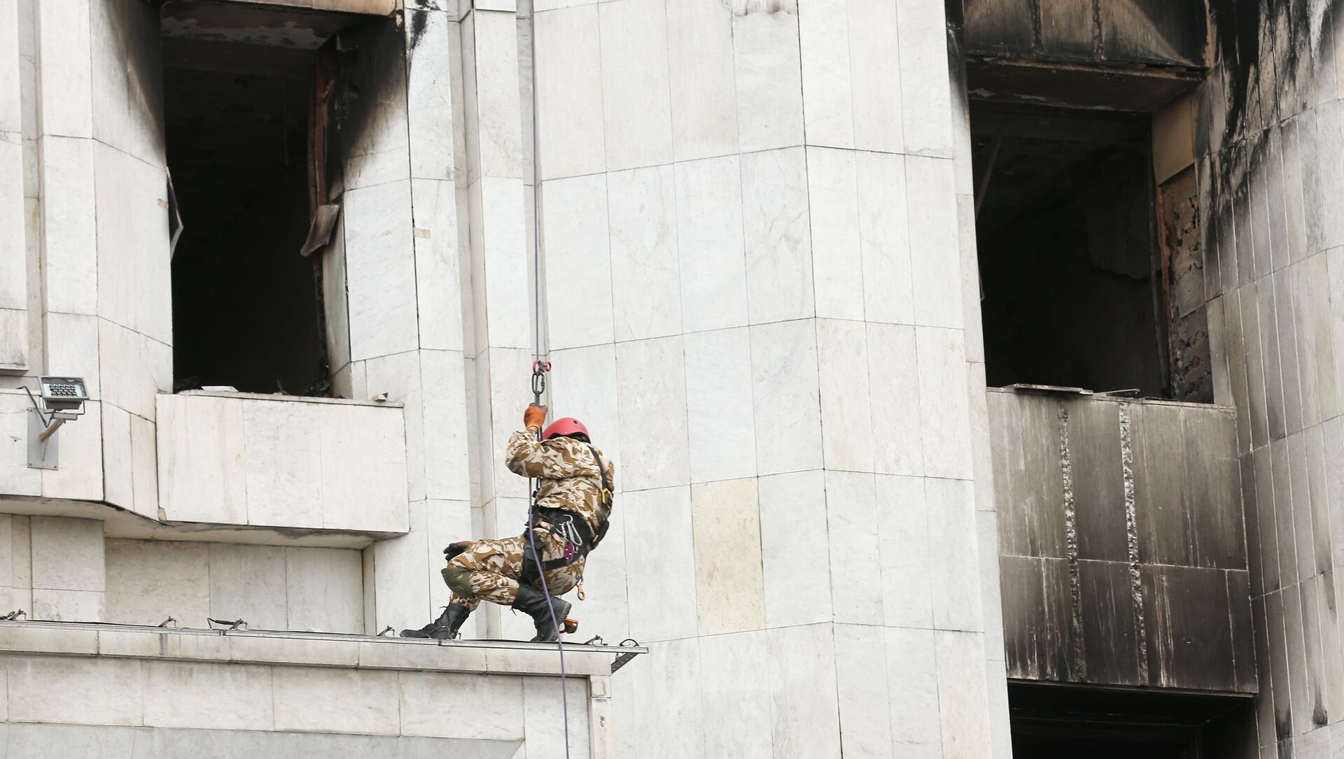 Рабочий во время восстановительных работ пострадавшего от пожара здания Акимата в Алма-Ате - Sputnik Казахстан, 1920, 17.01.2022