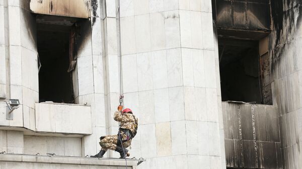 Рабочий во время восстановительных работ пострадавшего от пожара здания Акимата в Алма-Ате - Sputnik Қазақстан