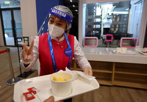 Персонал кафе подает еду  в обеденном зале Главного пресс-центра Олимпийских игр 2022 года в Пекине.  - Sputnik Казахстан