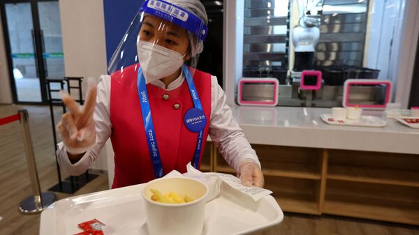 Персонал кафе подает еду  в обеденном зале Главного пресс-центра Олимпийских игр 2022 года в Пекине - Sputnik Казахстан
