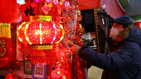 Покупатель смотрит на украшения для китайского Лунного Нового года на рынке в Пекине, Китай - Sputnik Казахстан