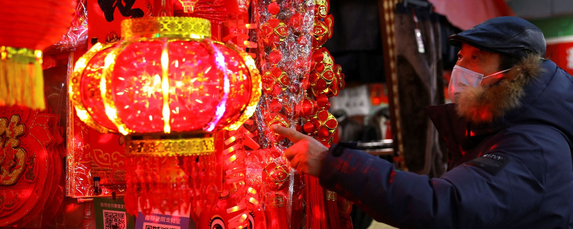 Покупатель смотрит на украшения для китайского Лунного Нового года на рынке в Пекине, Китай - Sputnik Казахстан, 1920, 13.03.2022