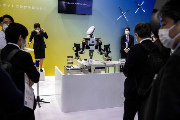 Көрмеге келушілер Kawada Robotics құрастырған Nextage гуманоид роботының іс-қимылын тамашалап тұр. - Sputnik Қазақстан