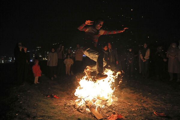 Мужчина прыгает через костер во время празднования Чахаршанбе Сури, древнего праздника огня в Тегеране.  - Sputnik Казахстан