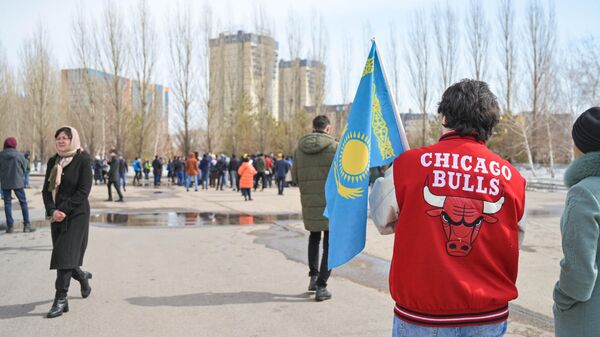Молодые люди с флагом Казахстана идут на митинг против блокировки соцсетей в Нур-Султане - Sputnik Казахстан