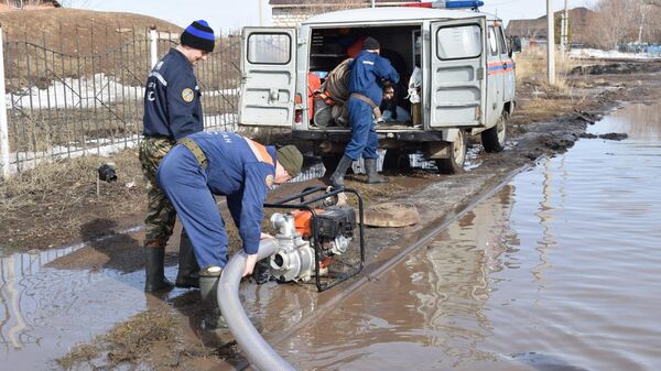 Сотрудники МЧС откачивают талую воду помпой  - Sputnik Казахстан