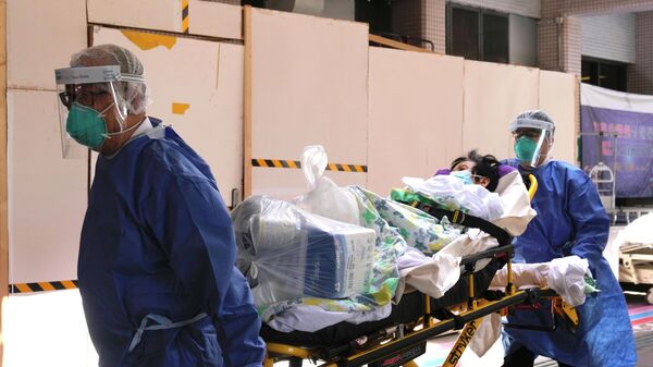 Медики в защитных костюмах везут пациента с коронавирусом в больницу - Sputnik Казахстан