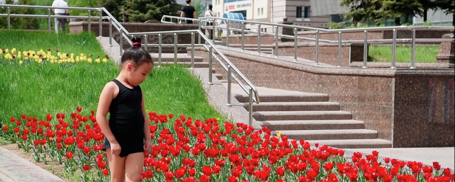Девочка идет по бордюру клумбы с тюльпанами  - Sputnik Казахстан, 1920, 01.09.2022