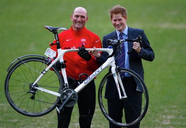 Британский принц Гарри держат велосипед вместе с Лоуренсом Даллаглио, бывшим игроком сборной Англии по регби, на стадионе Твикенхем в Лондоне. Принц Гарри проехал на велосипеде 1700 км из 2800 км по Европе, чтобы собрать деньги для благотворительного фонда, 2010 год. - Sputnik Казахстан