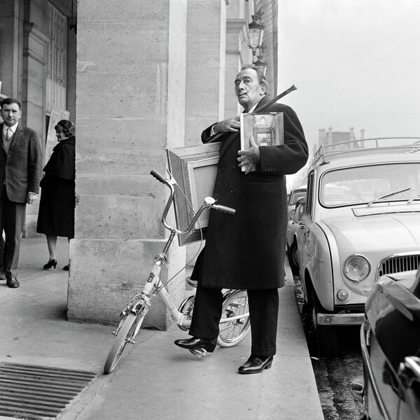 Испан суретшісі Сальвадор Дали өзінің соңғы картиналарын Париждегі көрмеге жеткізу үшін Риволи көшесінде велосипедпен жүріп өтті, 1967 жыл. - Sputnik Қазақстан