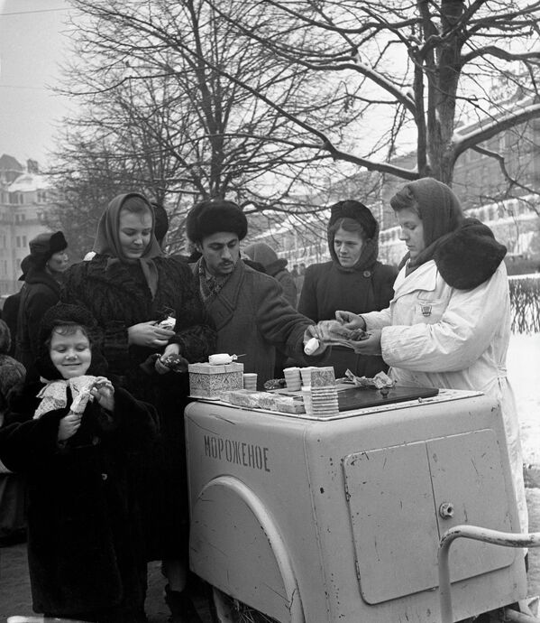 Несмотря на морозную погоду, жители города у стен Московского Кремля в Александровском саду с удовольствием пробуют мороженое 10 декабря 1955 года.  - Sputnik Казахстан