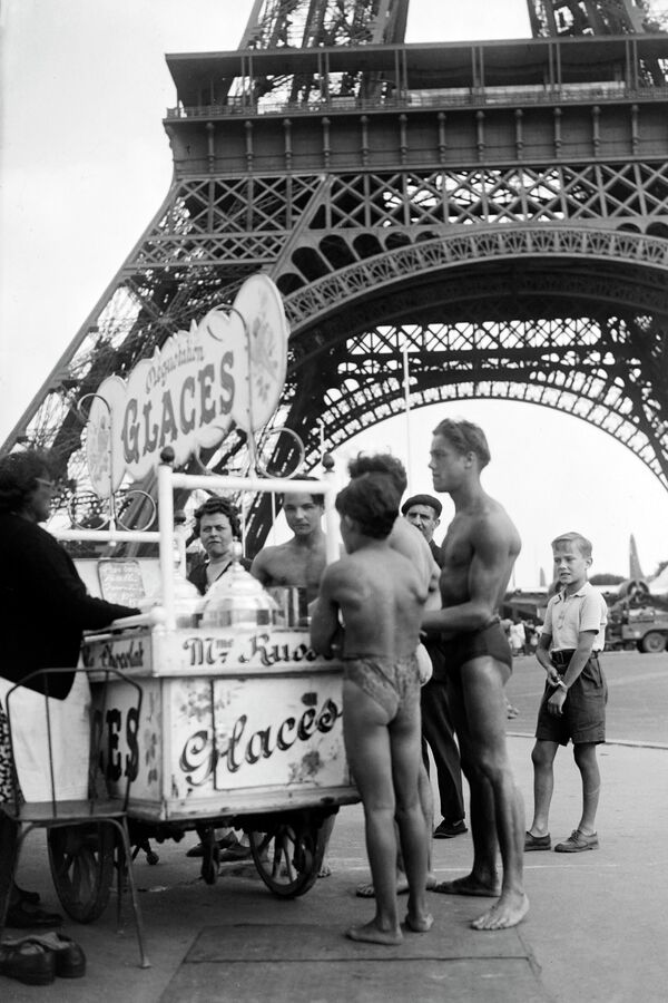 Молодые люди в купальниках покупают мороженое возле Эйфелевой башни, июль 1945 года.  - Sputnik Казахстан