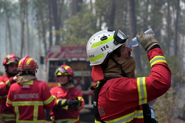 Пожарный промывает глаза водой в деревне Колмейас, недалеко от Лейрии, центральная Португалия. Тысячи пожарных в Португалии продолжают тушить пожары по всей стране, которые вынудили десятки людей эвакуироваться из их домов. - Sputnik Казахстан