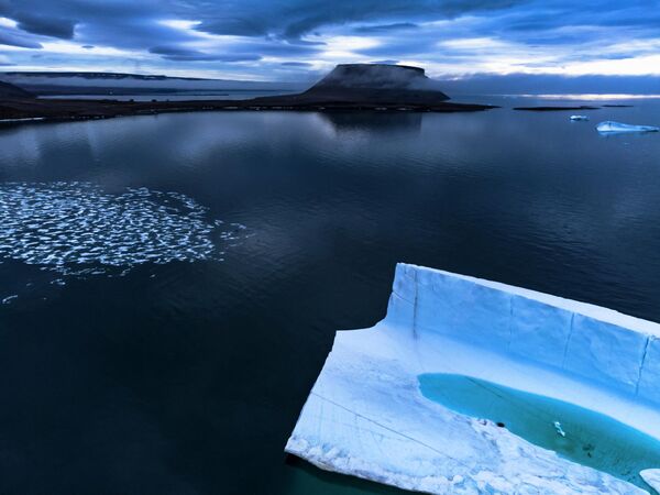 Тающий пруд внутри айсберга Гренландского ледяного щита. Таким образом самолет НАСА Gulfstream V, измеряя таяние ледников Арктики, демонстрирует, что айсберг тает не только снаружи, но и изнутри.  - Sputnik Казахстан
