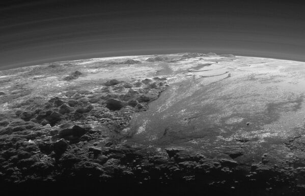 Плутон – Тенцинг Монтес (сол жақта алдыңғы шепте); Хиллари Монтес (сол жақ көкжиекте); Sputnik Planitia (оң жақта). Күннің батуы кезіндегі көріністе атмосфералық тұманның бірнеше қабаты қамтылған. - Sputnik Қазақстан