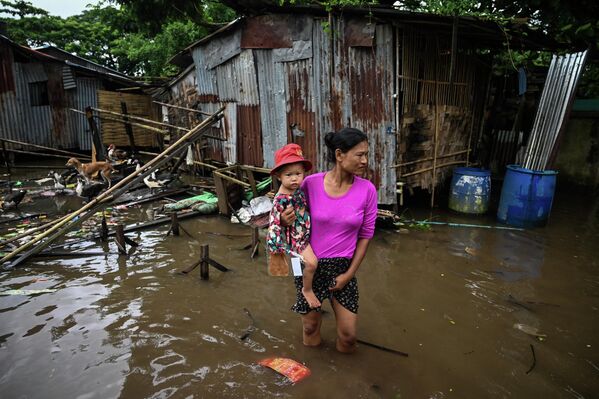 Молодая женщина идет по колено в воде после затопивших крупнейший в Мьянме город Янгон (бывшая Бирма) муссонных дождей.  - Sputnik Казахстан