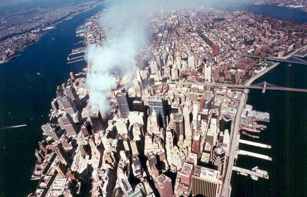 Вид сверху со стороны южного Манхэттена на дымящиеся руины башен-близнецов, разрушенных в результате теракта 11 сентября 2001 года.  - Sputnik Казахстан