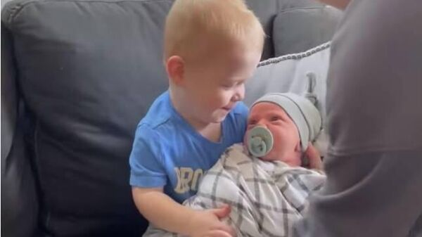 Мальчик впервые держит на руках новорожденного брата - очень трогательное видео - Sputnik Қазақстан