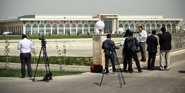 Журналисты проводят съемки рядом с Конгресс-центром, в котором проходят заседания саммита Шанхайской организации сотрудничества.  - Sputnik Казахстан