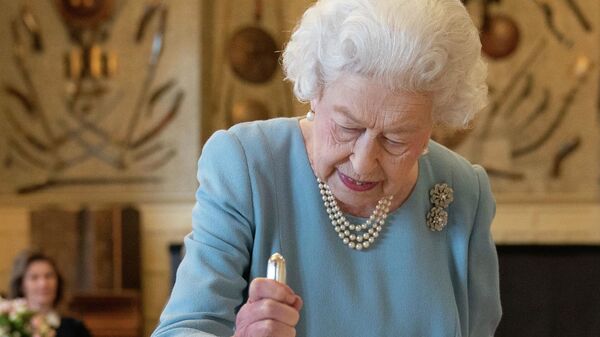 Королева Великобритании Елизавета II разрезает торт, чтобы отпраздновать начало семидесятой годовщины ее правления, 2022 год - Sputnik Казахстан