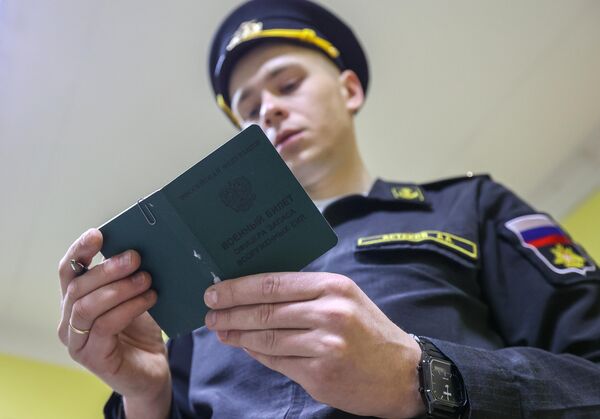 Сотрудник военного комиссариата в Мурманске изучает военный билет офицера запаса ВС.  - Sputnik Казахстан