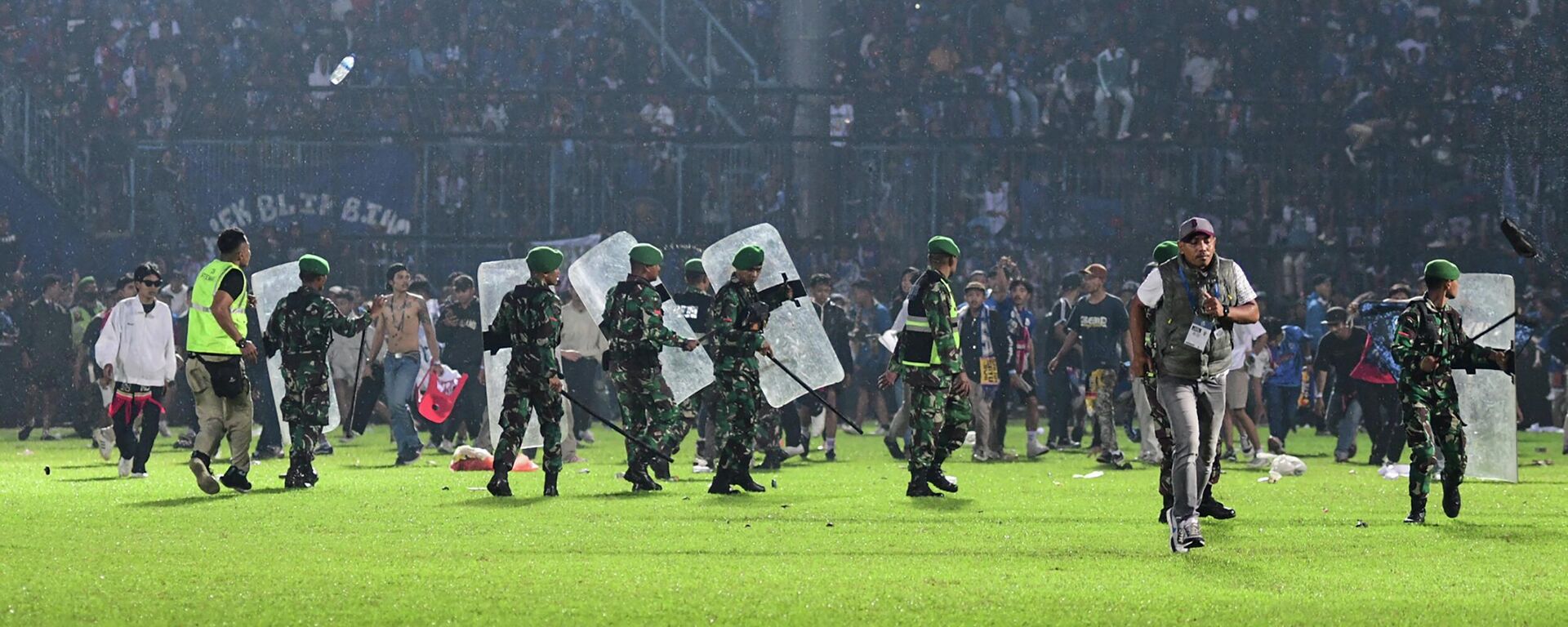 Военнослужащие индонезийской армии охраняют поле после футбольного матча между футбольными клубами Arema FC и Persebaya Surabaya на стадионе Kanjuruhan - Sputnik Казахстан, 1920, 02.10.2022