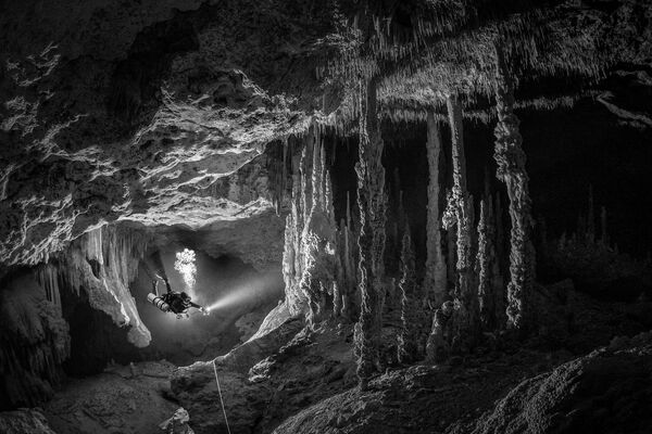 Снимок фотографа Тома Сент-Джорджа из Мексики. На фото изображен дайвер в подводной пещере. - Sputnik Казахстан