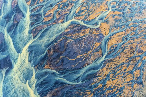 Снимок &quot;Плетеная река&quot; американского фотографа Кристин Райт. Ярко окрашенные ледниковые отложения &quot;превращают&quot; исландский пейзаж в нечто особенное, делая изображение похожим на компьютерную графику. - Sputnik Казахстан