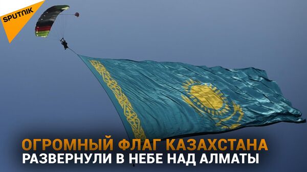 Флаг Казахстана размером с четверть футбольного поля развернули в небе над Алматы  -  видео - Sputnik Казахстан
