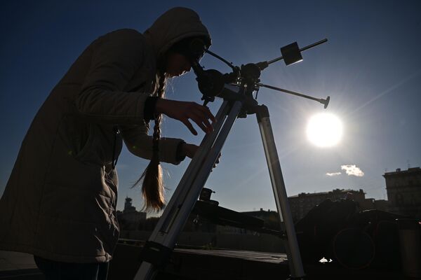 Бойжеткен телескоп арқылы Мәскеудегі күннің жартылай тұтылуын бақылап тұр. - Sputnik Қазақстан