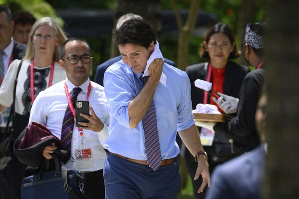 Канада премьер-министрі Джастин Трюдо G20 саммиті аясында аптап ыстықты жеңілдету үшін терлеген мойнын орамалмен сүртіп жатыр. - Sputnik Қазақстан
