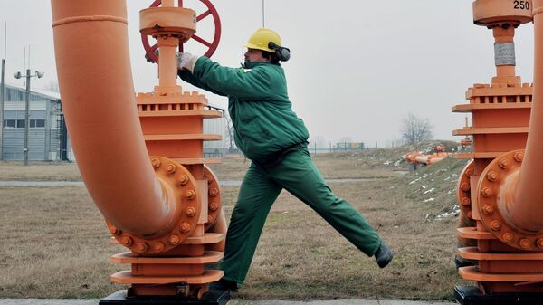 Рабочий поворачивает вентиль газопровода на компрессорной станции в Венгрии, архивное фото - Sputnik Казахстан