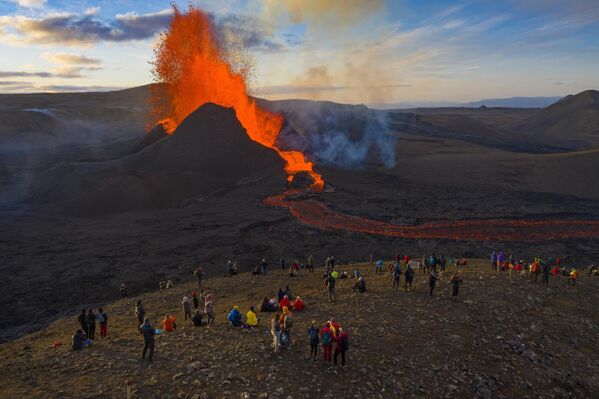 Горы - это безумное приключение, попытка получить свой &quot;адреналин&quot;. На фото: люди наблюдают за извержением вулкана Фаградальсфьялл на полуострове Рейкьянес в Исландии.  - Sputnik Казахстан